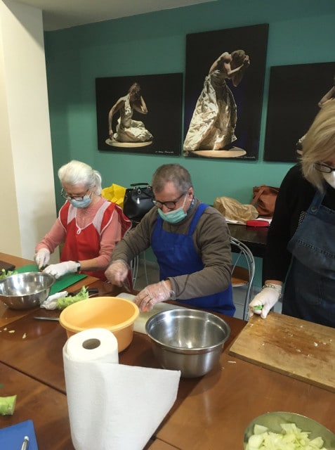 Dwoje seniorów podczas pracy przy stole podczas warsztatów kulinarnych