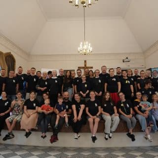 Grupa kilkudziesięciu osób w granatowych koszulkach