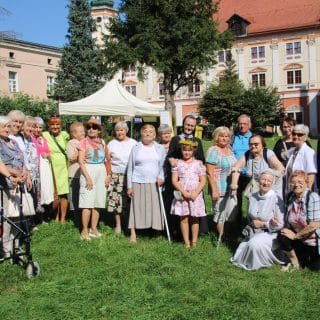 Grupa kilkudziesięciu osób pozuje do zdjęcia na tle opactwa w Henrykowie