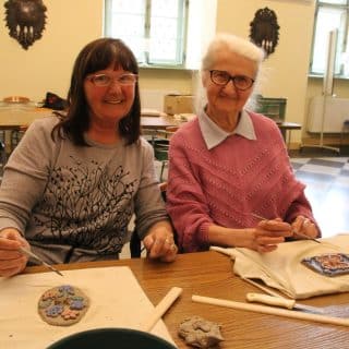 Dwie seniorki przy stole podczas warsztatów rękodzieła