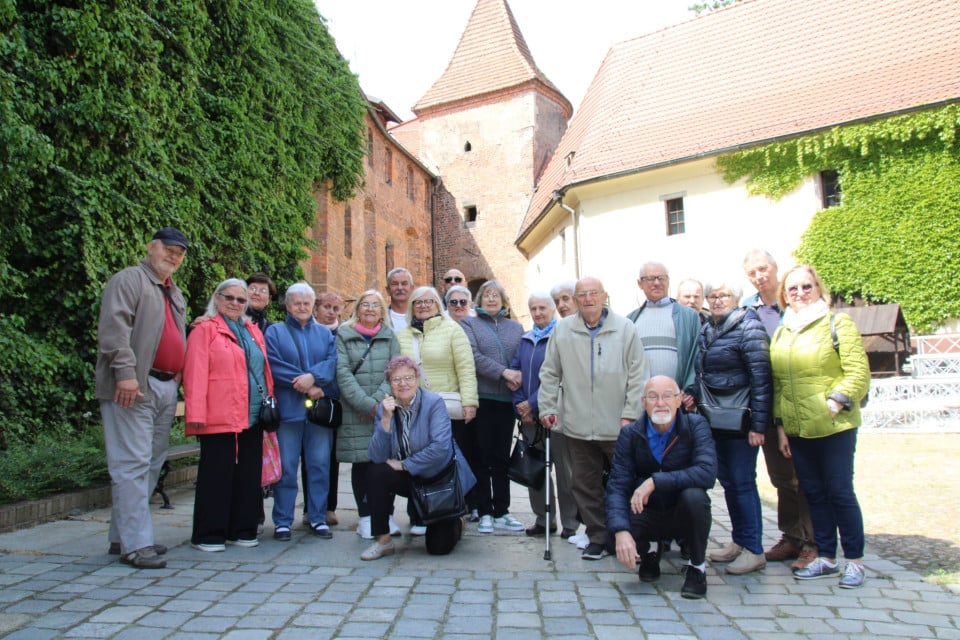 Grupa seniorów na tle budynków arsenału miejskiego