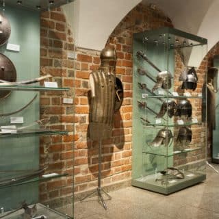 Gabloty wystawowe prezentujące zbroje, miecze i hełmy