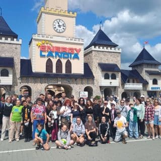 Zdjęcie grupowe kilkudziesięciu osób na tle budynku z napisem Energylandia