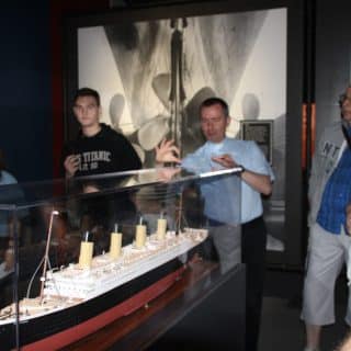 Migający mężczyzna przy gablocie ze statkiem