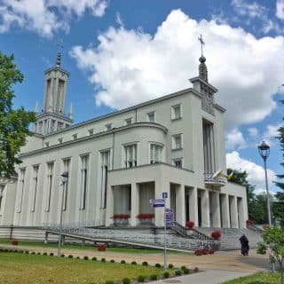 Duży kościół na tle nieba z białym obłokiem
