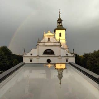 Kościół na tle pochmurnego nieba odbija się w szybie
