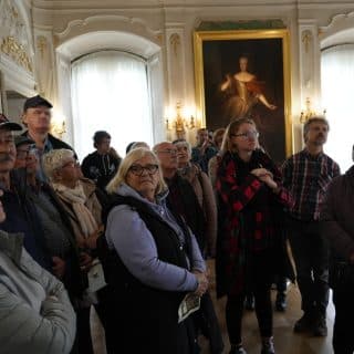 Grupa osób w bogato zdobionym pomieszczeniu