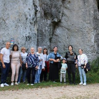 Kilkanaście osób pozuje do zdjęcia przy skale