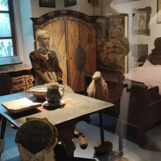 Wystawa prezentująca dawną izbę mieszkalną z licznymi sprzętami domowymi