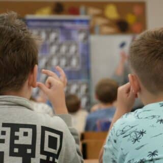 Dwóch migających chłopców w sali lekcyjnej