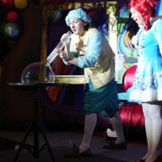 Dwie kolorowe postacie podczas przedstawienia z bańką mydlaną