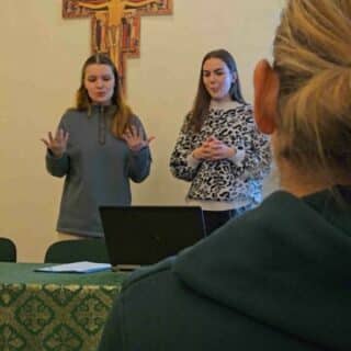 Dwie dziewczyny podczas wykładu przy stoliku z laptopem