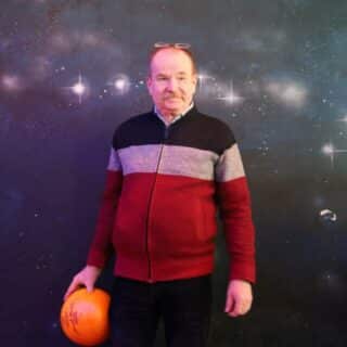 Mężczyzna trzyma w dłoni kulę do gry w kręgle